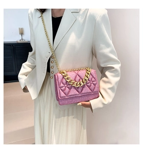 Detail of pink quilted chain bag with gold hardware worn with a white blazer outfit