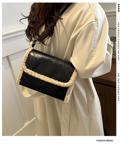 Detail of vintage black faux leather crossbody bag with cream wool trim on a model