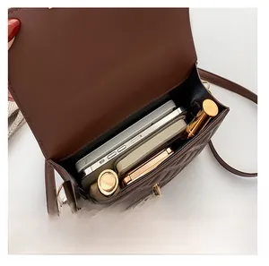 Internal capacity of dark brown quilted crossbody bag showing space for phone and makeup