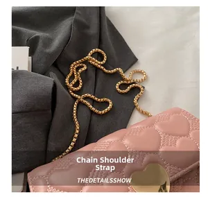 Détail du sac matelassé rose clair avec bandoulière chaîne et fermoir cœur doré