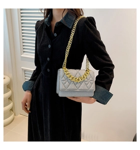 Detail shot of silver sequin quilted texture and premium gold chain on a crossbody bag