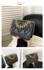 Detail of black quilted chain bag with pearlescent glitter finish and chunky gold handle