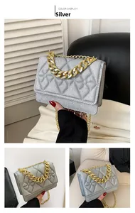 Detail of silver sequin quilted crossbody bag featuring a thick gold decorative chain