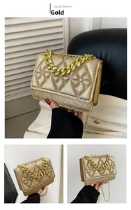 Detail of gold glitter quilted flap bag with dual metallic chain straps and texture