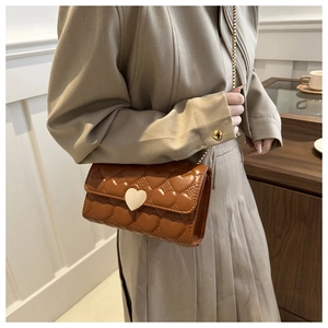 Détail du sac matelassé marron avec motifs cœurs gaufrés et fermoir cœur doré