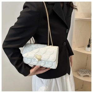 Vue détaillée du sac bandoulière blanc matelassé avec fermoir doré en forme de cœur