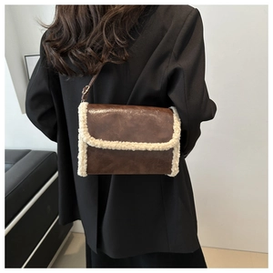 Brown vintage leather shoulder bag with white faux fur trim shown on model