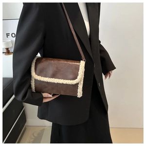Ethnic style crossbody bag with brown leather and white faux fur trim shown on model