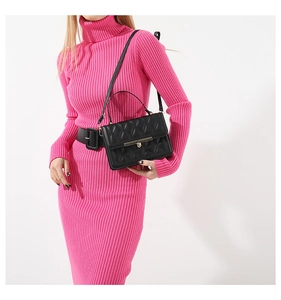Detail of black quilted leather shoulder bag with metallic clasp worn by a model