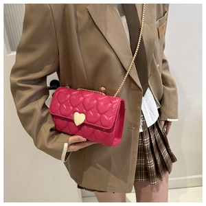 Détail du sac bandoulière rose avec surpiqûres en cœur et fermoir cœur doré
