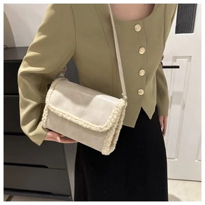 Cream leather crossbody bag with plush faux fur trim and adjustable shoulder strap