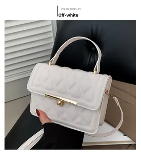 Detail of cream white quilted crossbody bag with gold buckle and adjustable strap