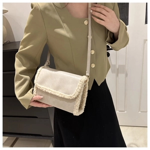 Detail of cream crossbody bag with plush faux fur trim and sleek leather texture