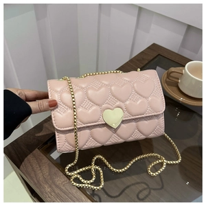Détail du sac à cœur matelassé rose avec chaîne dorée et fermoir en forme de cœur