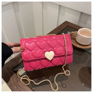Détail du sac bandoulière fuchsia avec matelassage cœurs et fermoir doré cœur