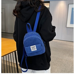 Detailopname van de blauwe corduroy mini-rugzak met focus op de stoffen textuur