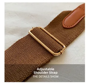Macro view of adjustable brown woven strap with gold metal buckle on tote bag
