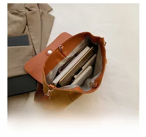 Detail showing spacious interior capacity of the mustard yellow shoulder bag with daily items