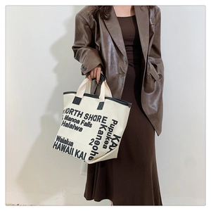 Detail of canvas tote bag with black leather handles and Hawaii city name printing