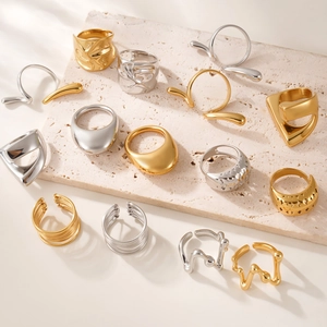 Ensemble de bagues ajourées en acier titane or 18K et argent sur fond pierre