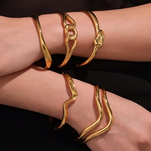 Polished 18k gold wave bangle set with five unique minimalist stainless steel designs