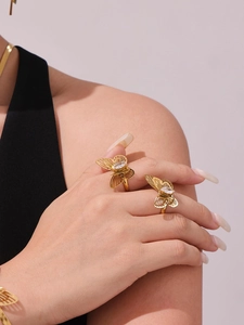 Close-up of golden butterfly rings with hollow wings and marquise-cut zircon stones