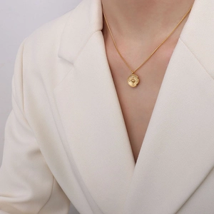 Elegant gold titanium steel compass necklace with starburst zircon pendant on a woman