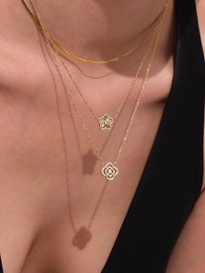 Gros plan de colliers multicouches plaqués or 18 carats avec pendentifs étoile et zircon