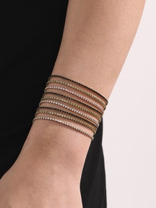 Gros plan de bracelets tennis en zircon coloré empilés en acier plaqué or 18 carats
