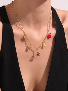 Detalle de collar de cadena de clip dorado con colgantes de frutas en esmalte de color
