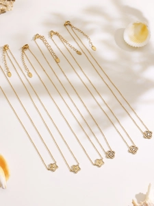Détail à plat de colliers en acier inoxydable plaqué or 18 carats avec pendentifs trèfles