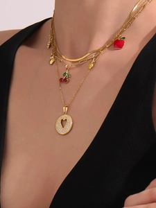 Primer plano de collares de oro 18K con colgantes de cereza, manzana y fresa