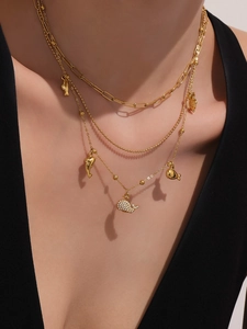 Dettaglio collana multistrato in oro 18k con pendenti a delfino e zirconi marini brillanti