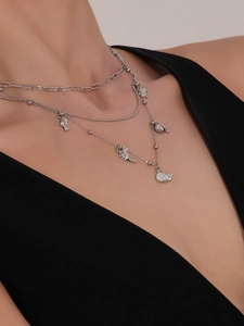 Dettaglio di ciondoli a forma di delfino in argento su collana a catena a graffetta e sfere