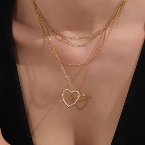 Three-layer gold necklace featuring paperclip chain and heart arrow pendant with zircons