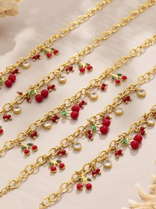 Détails des pendentifs cerises rouges avec feuilles vertes et zircons sur chaînes dorées