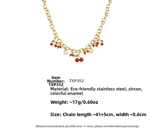 Détail du pendentif cerise rouge avec feuille verte et zircon sur chaîne dorée en acier