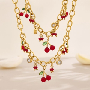 Ensemble collier et bracelet dorés avec pendentifs cerises rouges et accents de zircon