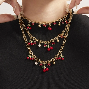 Collier doré à trois couches avec pendentifs cerises rouges et accents en zircon