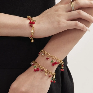 Parure cerise dorée avec pendentifs émaillés rouges et zircons sur le mannequin
