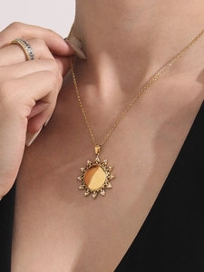 Detail van de 18k vergulde zonnebloem hanger ketting met zirkoon kristallen op een model
