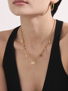 Golden necklace with cubic zirconia charms and twisted hoop earrings worn by a model
