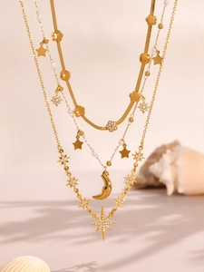 Dettaglio della collana a tre strati dorata con stelle, luna e pendenti in zircone