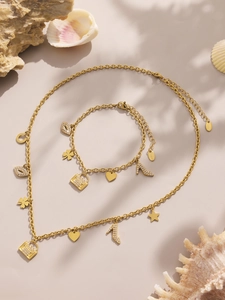 Detail of gold stainless steel jewelry set featuring zircon handbag and shoe charms