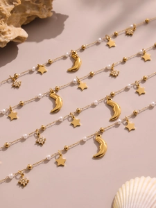 Vista macro di ciondoli a stella e luna in oro 18K con perle e zirconi scintillanti