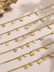 Detail of 18K gold plated charms with zircon lips, handbags, and hearts on necklaces