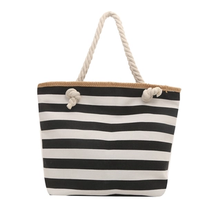Black and white striped canvas tote bag with woven trim and thick rope shoulder handles
