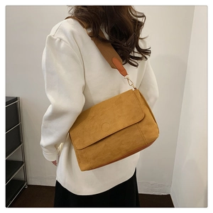Ginger suede tote bag with brown wide strap shown on model in a minimalist setting