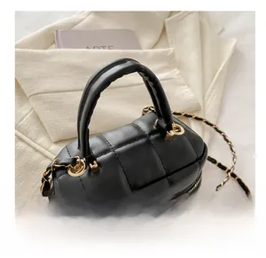 Détail d'un sac à main noir en cuir PU matelassé avec dorures et bandoulière chaîne