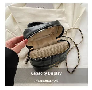Détail du sac bandoulière noir matelassé montrant la capacité avec bandoulière dorée